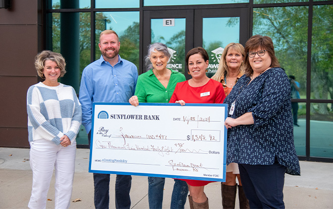 four people holding check